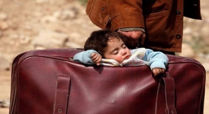 صورة طفلة سورية نائمة داخل حقيبة والدها أثناء فراره تهز وجدان العالم صورة طفلة سورية نائمة داخل حقيبة والدها أثناء فراره تهز وجدان العالم