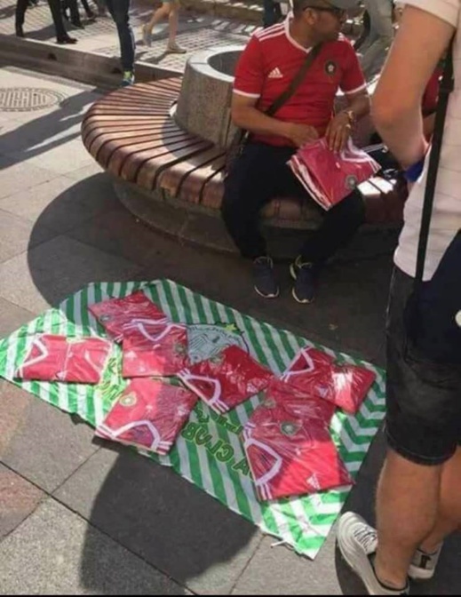 من طرائف المونديال: فراش مغربي يعرض قمصان "الأسود" للبيع على الرصيف بروسيا من طرائف المونديال: فراش مغربي يعرض قمصان "الأسود" للبيع على الرصيف بروسيا