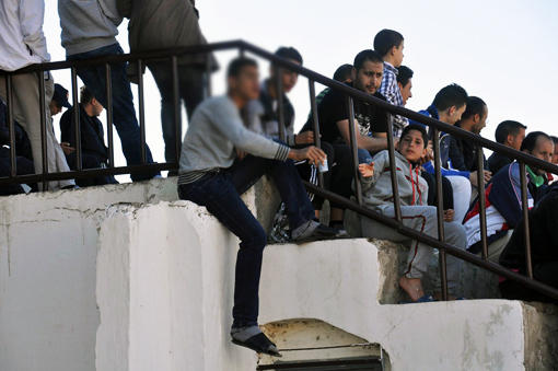 صورة اليوم :بسبب هشاشة مدرجات الملعب.. متفرج يجلس في الحافة لمتابعة أطوار المباراة