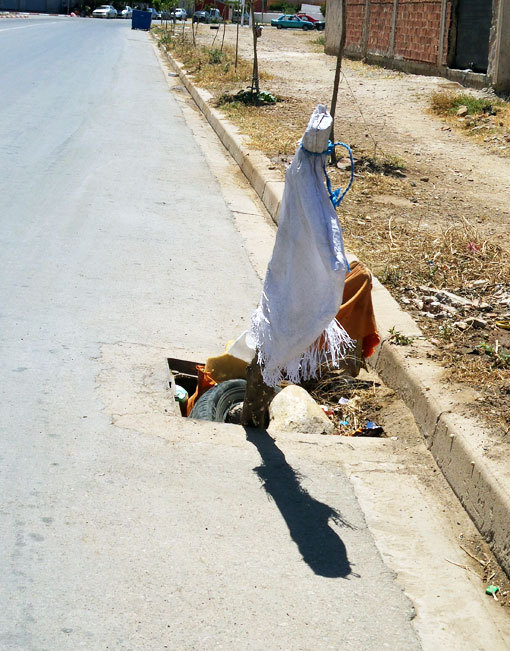 صورة اليوم : عمود براية بيضاء لتنبيه المارة على مجرى للصرف الصحي بدون بلوعة