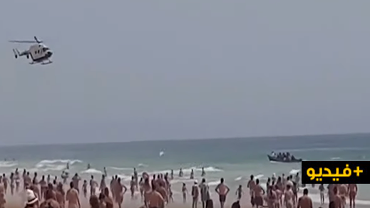 شاهدوا.. زورقٌ للمهاجرين المغاربة يرسو على شاطئ إسباني وسط آلاف السياح